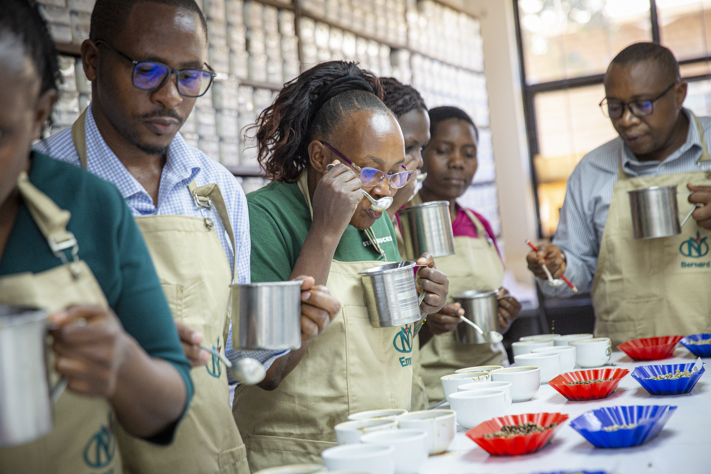 A line of QC team members cupping coffee with spoons and cups